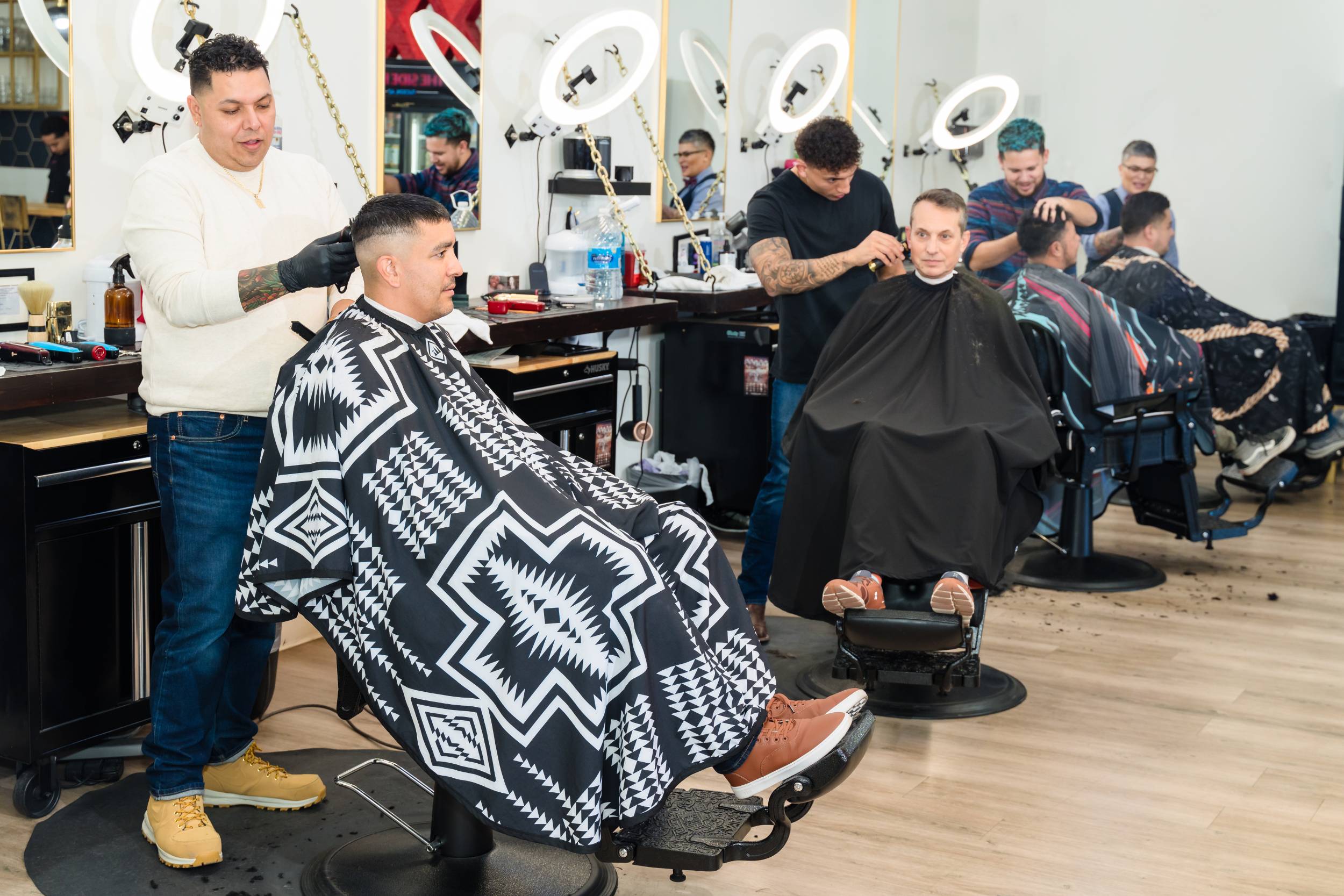 Interior of 81 Barbers showing barbers at work with clients in a stylish, modern barber shop.